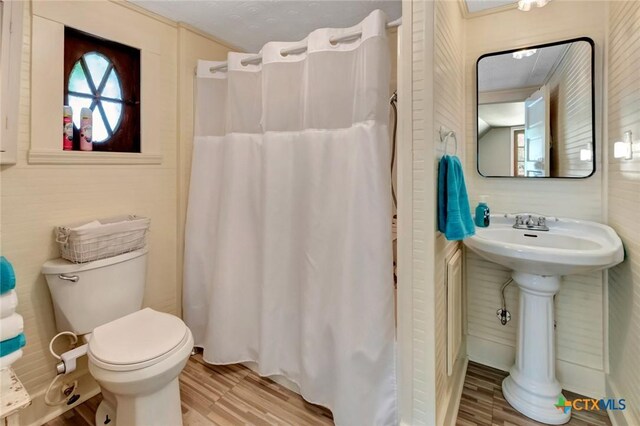 304 W Putnam, Ganado, TX 77962 - full bath featuring wood finished floors, toilet, curtained shower, and a sink