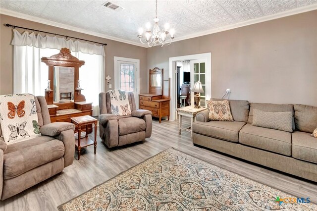 304 W Putnam, Ganado, TX 77962 - living room featuring a chandelier, light wood-type flooring, and crown molding