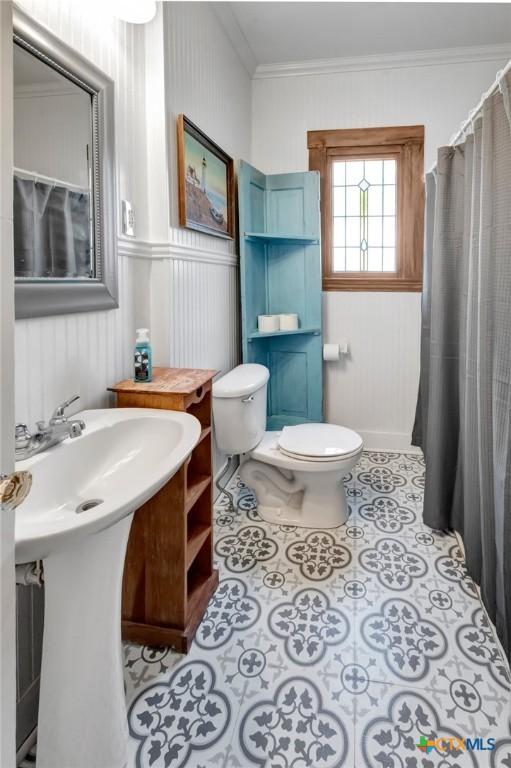 304 W Putnam, Ganado, TX 77962 - full bathroom with toilet, crown molding, tile patterned floors, and a wainscoted wall