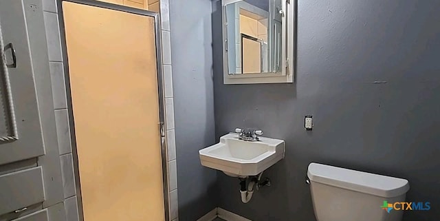 bathroom with walk in shower, sink, and toilet