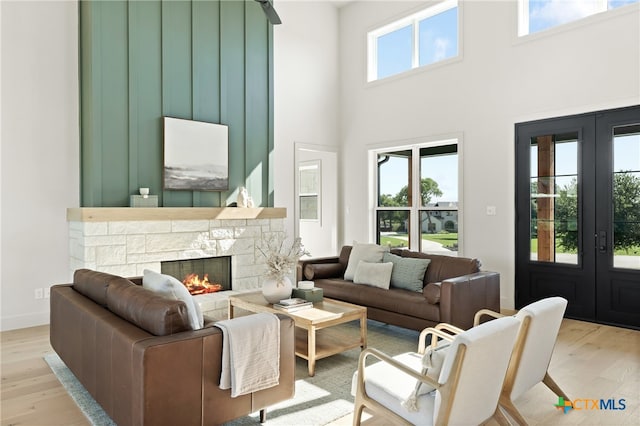 living room with plenty of natural light, light wood-type flooring, and french doors