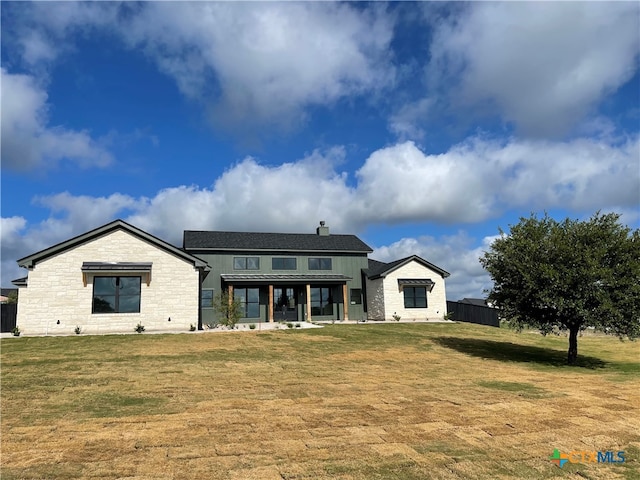 back of property featuring a lawn