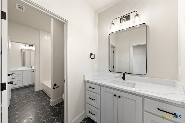 full bathroom featuring washtub / shower combination, vanity, and toilet