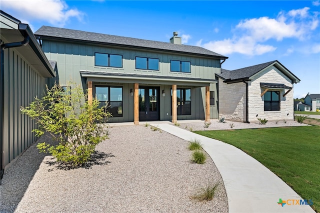 view of front of property featuring french doors and a front lawn