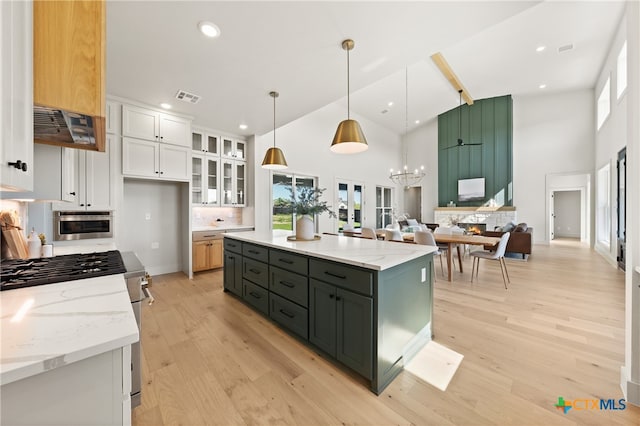 kitchen featuring a wealth of natural light, white cabinetry, a kitchen island, and pendant lighting