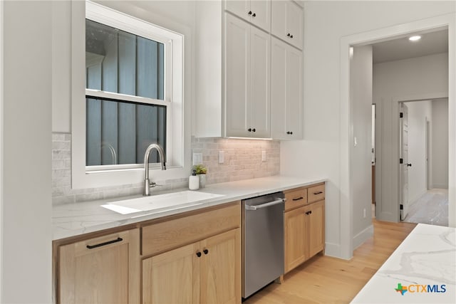 kitchen featuring white cabinetry, dishwasher, sink, and light hardwood / wood-style floors