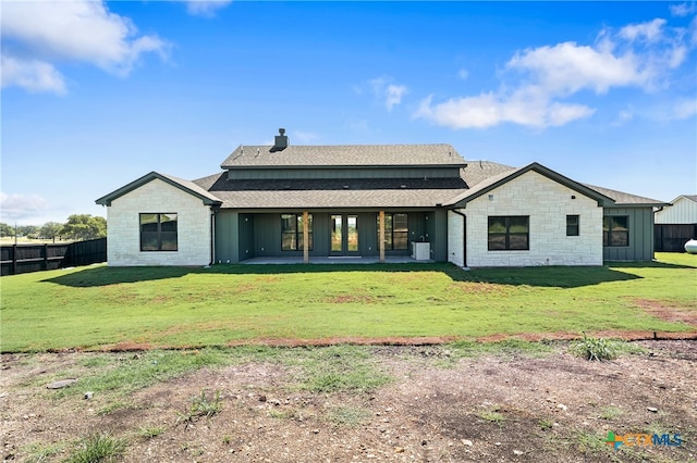 rear view of property featuring a yard