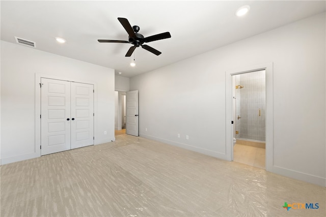 unfurnished bedroom with a closet, ensuite bath, and ceiling fan