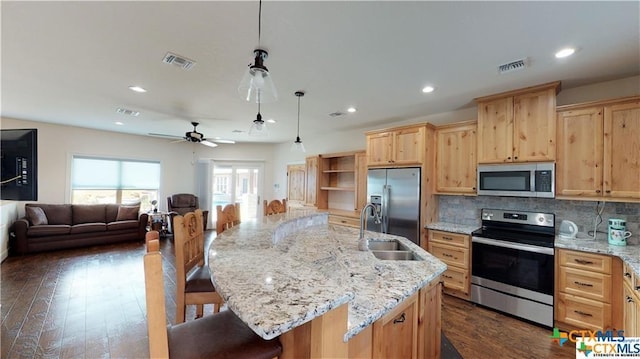 158 Sendera Loop, Victoria, TX 77904 - kitchen with stainless steel appliances, a sink, light brown cabinets, open floor plan, and a kitchen bar