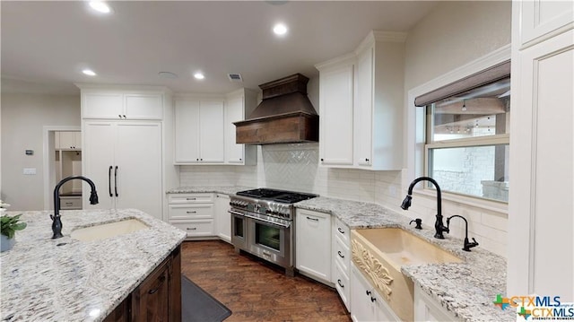 158 Sendera Loop, Victoria, TX 77904 - kitchen featuring custom range hood, double oven range, a sink, backsplash, and recessed lighting