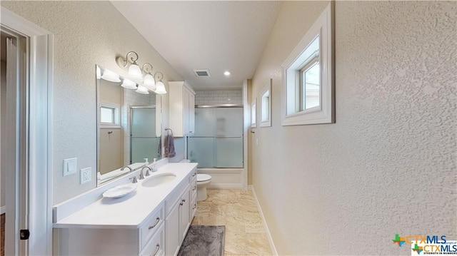 158 Sendera Loop, Victoria, TX 77904 - bathroom with toilet, vanity, a textured wall, enclosed tub / shower combo, and baseboards