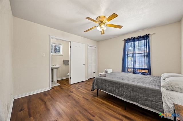 bedroom with a textured ceiling, dark hardwood / wood-style flooring, ceiling fan, and sink