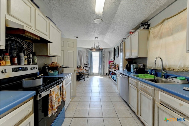 kitchen with stainless steel appliances, light tile patterned flooring, sink, a textured ceiling, and decorative light fixtures