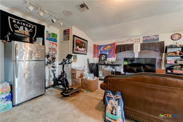 carpeted bedroom with lofted ceiling, a textured ceiling, and stainless steel fridge