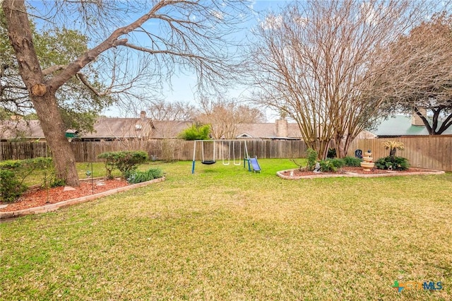 view of yard featuring a fenced backyard and a playground