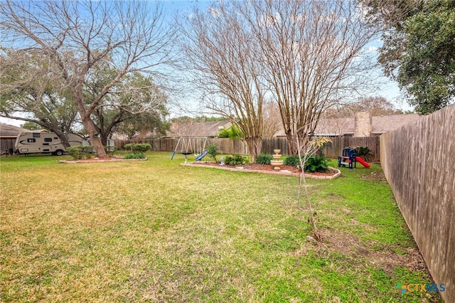 view of yard featuring a playground and a fenced backyard