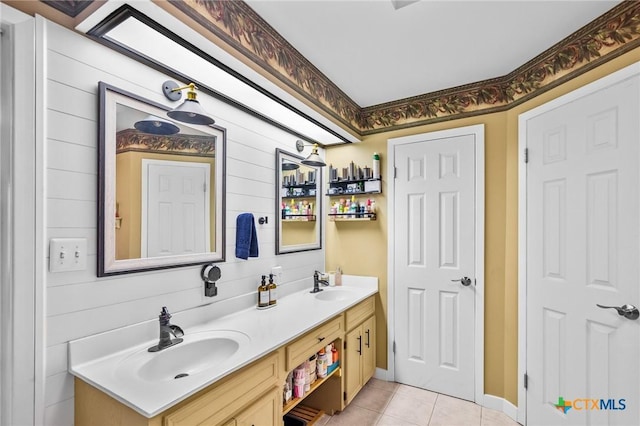 full bathroom featuring double vanity, tile patterned flooring, a sink, and wooden walls