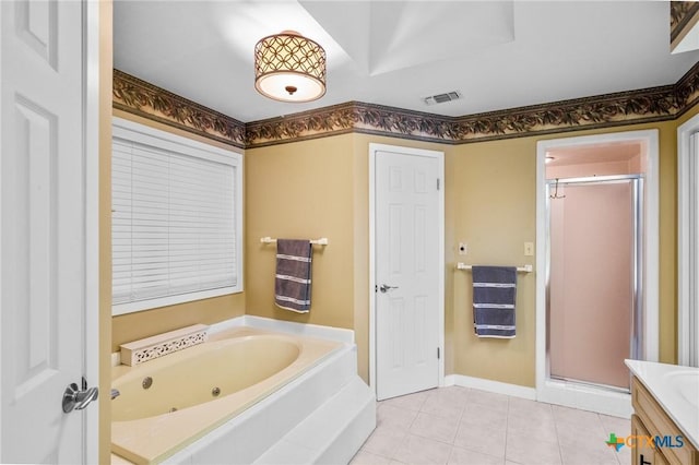 bathroom featuring tile patterned flooring, vanity, baseboards, a tub with jets, and a stall shower