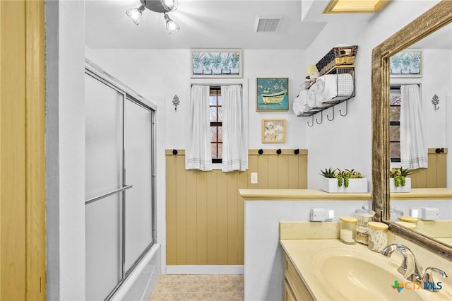 bathroom featuring vanity, shower / bath combination with glass door, tile patterned flooring, and visible vents