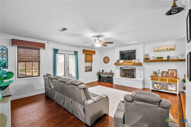 living room featuring dark wood-style flooring, french doors, a fireplace, visible vents, and baseboards