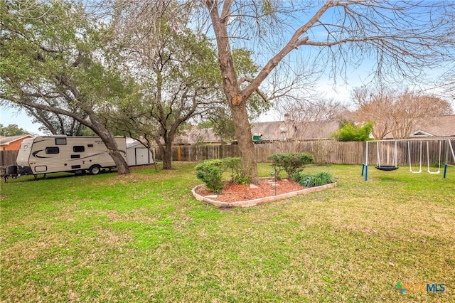 view of yard featuring an outbuilding, a storage unit, and a fenced backyard