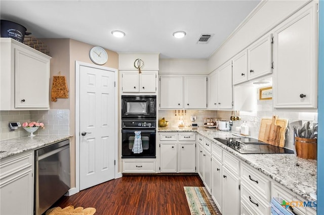 kitchen featuring light stone counters, dark wood-style flooring, white cabinets, black appliances, and tasteful backsplash