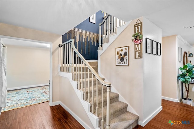 stairway featuring baseboards and wood finished floors