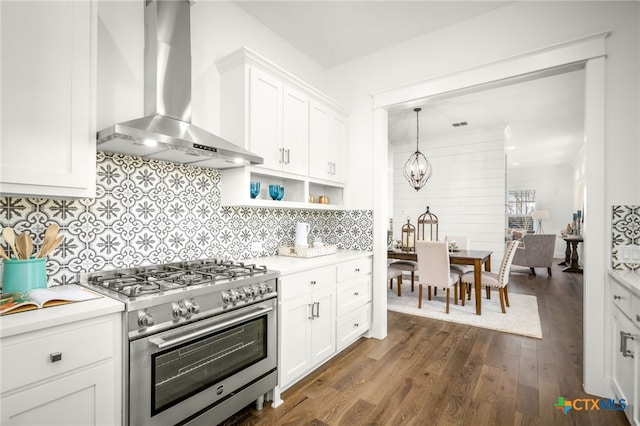 kitchen featuring wall chimney range hood, a chandelier, light countertops, dark wood-style floors, and high end range