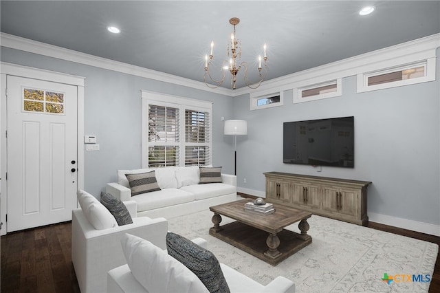 living room featuring crown molding, dark hardwood / wood-style floors, and an inviting chandelier