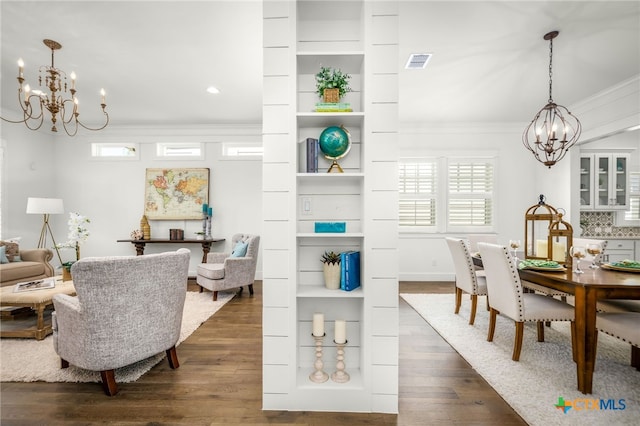 dining space featuring visible vents, an inviting chandelier, ornamental molding, and dark wood-style floors