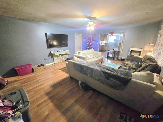 living room with ceiling fan, hardwood / wood-style floors, and a textured ceiling