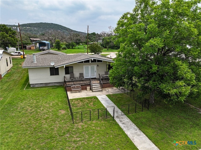 rear view of house featuring a lawn and a deck with mountain view