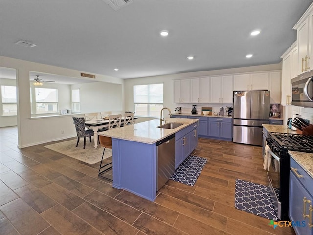 327 Steele Way, Cibolo, TX 78108 - kitchen featuring stainless steel appliances, a sink, blue cabinetry, white cabinetry, and recessed lighting