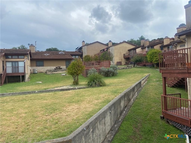 116 Campbell Dr Unit 9, Canyon Lake, TX 78133 - view of green lawn featuring a wooden deck, a residential view, and stairs