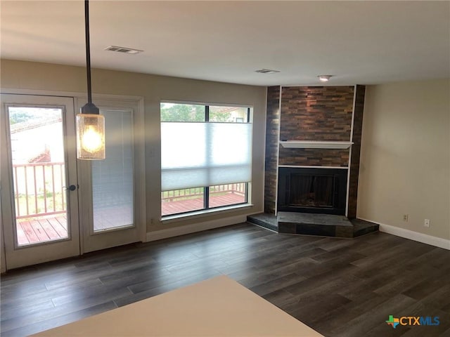 116 Campbell Dr Unit 9, Canyon Lake, TX 78133 - unfurnished living room with dark wood-style floors, a stone fireplace, and baseboards