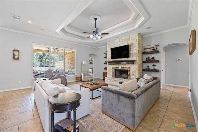 965 Ridgeoak Dr, Belton, TX 76513 - living area with arched walkways, a stone fireplace, ornamental molding, ceiling fan, and a raised ceiling