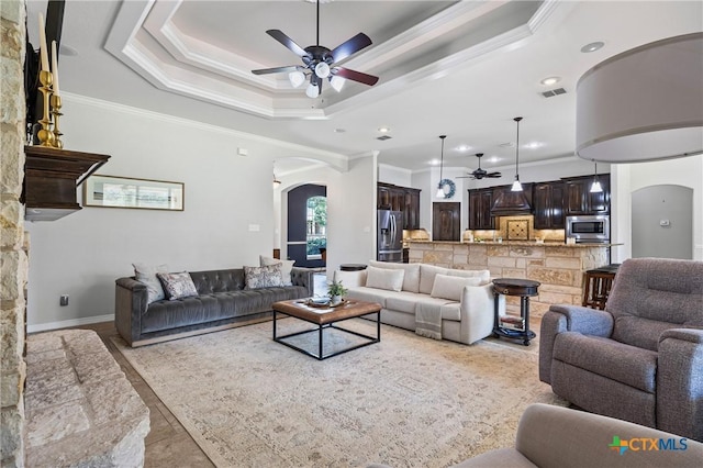 965 Ridgeoak Dr, Belton, TX 76513 - living area with arched walkways, a ceiling fan, crown molding, a raised ceiling, and recessed lighting