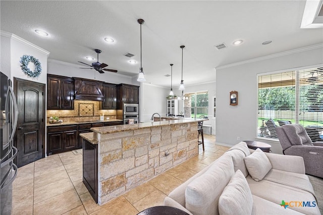 965 Ridgeoak Dr, Belton, TX 76513 - kitchen with open floor plan, appliances with stainless steel finishes, decorative backsplash, ornamental molding, and premium range hood
