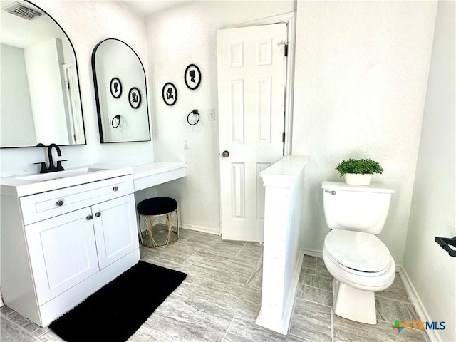 bathroom with toilet and vanity