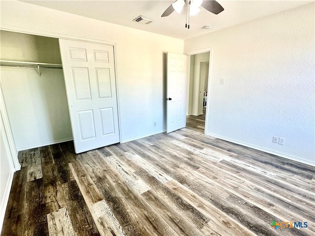 unfurnished bedroom with ceiling fan, a closet, and hardwood / wood-style floors