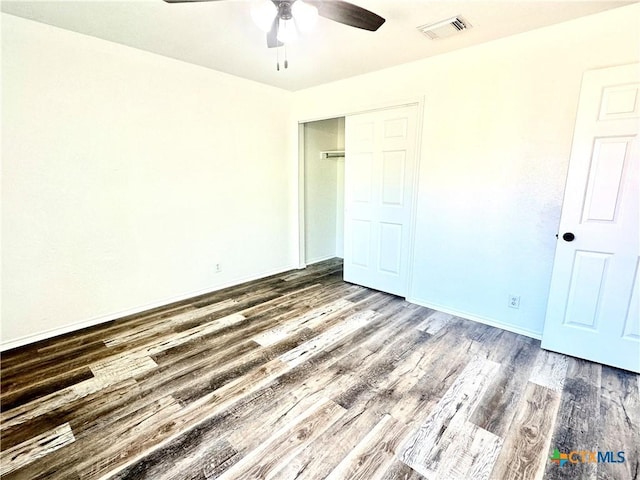 unfurnished bedroom featuring a closet, ceiling fan, and dark hardwood / wood-style floors