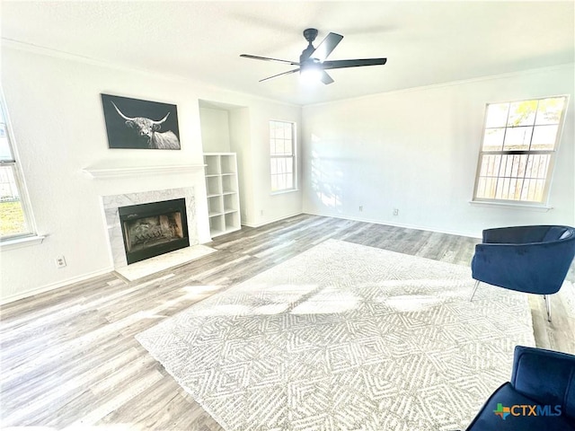 living room with wood-type flooring, ceiling fan, and ornamental molding