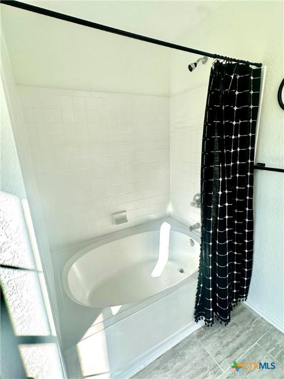 bathroom with shower / bath combination with curtain