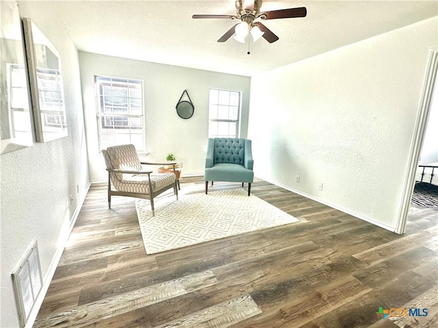 sitting room with ceiling fan and dark hardwood / wood-style floors