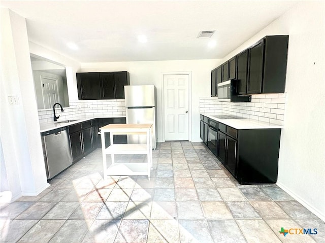 kitchen featuring stainless steel appliances, tasteful backsplash, and sink