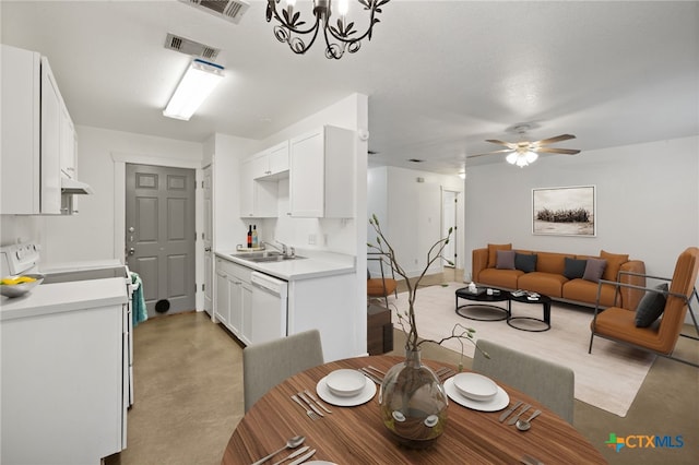 dining space with sink and ceiling fan with notable chandelier