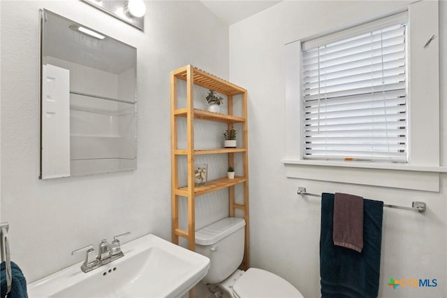 bathroom with a shower, toilet, and sink