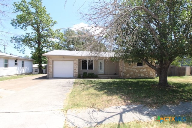 ranch-style house featuring a garage and a front lawn