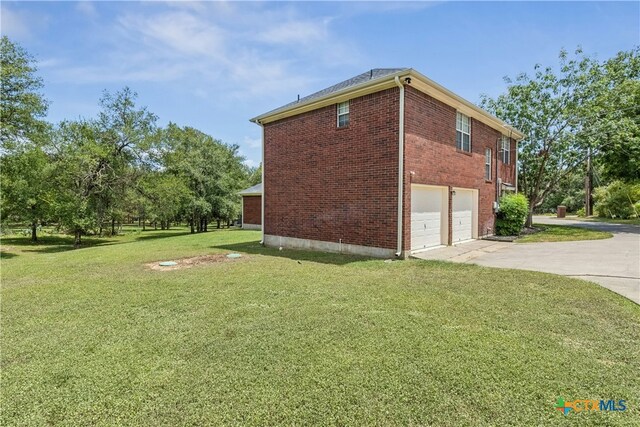 514 Duncan Dr, San Marcos, TX 78666 - view of side of property featuring concrete driveway, brick siding, an attached garage, and a yard