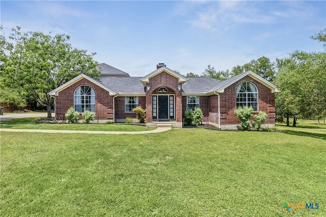 514 Duncan Dr, San Marcos, TX 78666 - view of front of house with brick siding, a front yard, a chimney, and roof with shingles